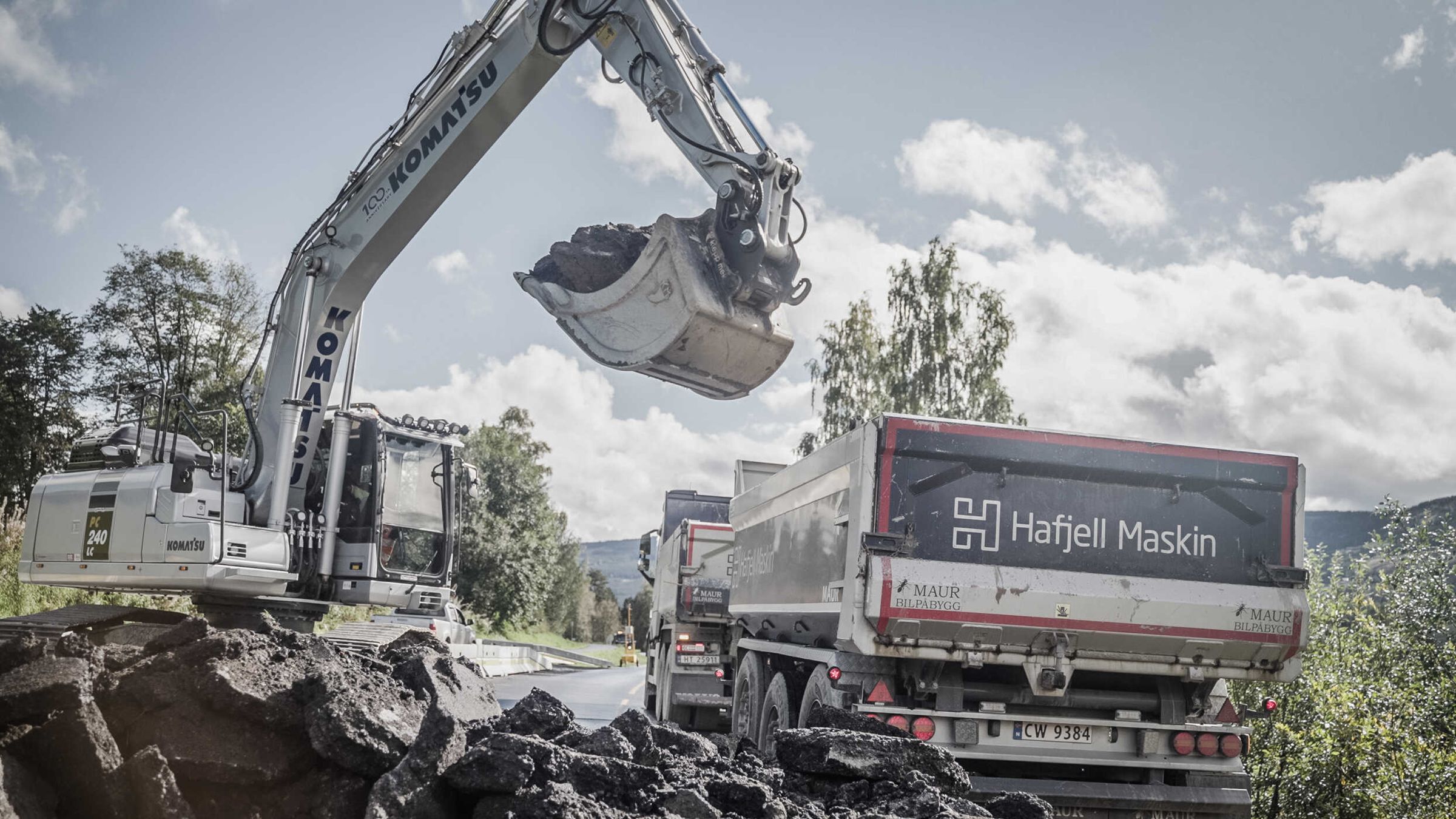 Gravemaskin fra Hafjell Maskin laster masse på en av firmaets egne lastebiler